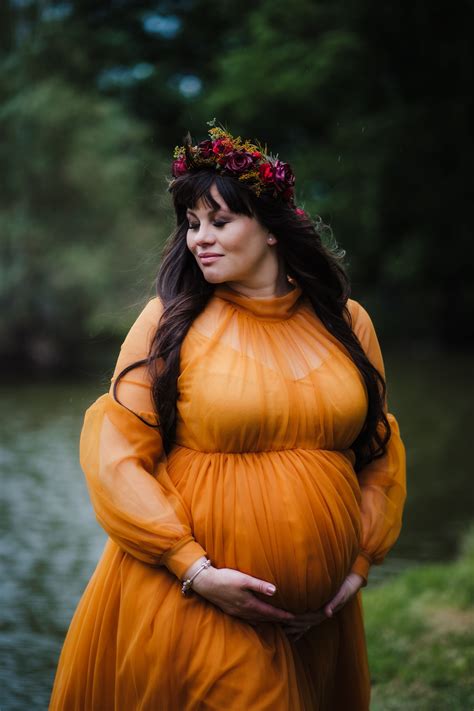 Podzimní les s barevným listím jako pozadí pro těhotenské focení