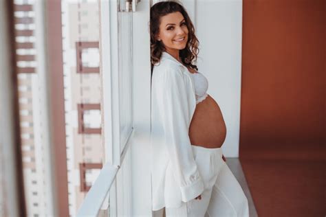 Detailní záběr na těhotenské bříško s jemnými doplňky