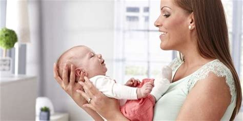 Maminka s miminkem využívající kojící polštář pro pohodlné krmení