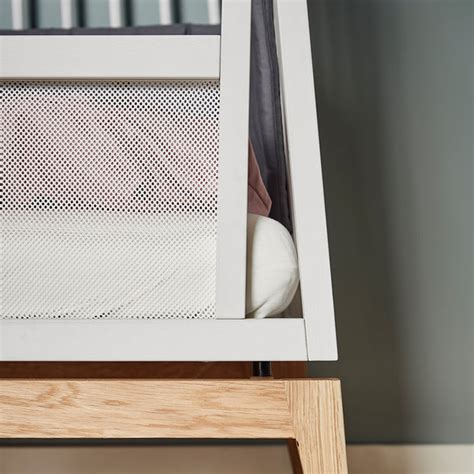 Interiér dětské postýlky Leander Luna s dominantními přírodními materiály a minimalistickým designem.