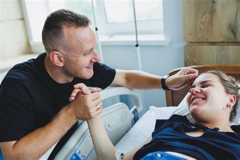 žena v porodním sále s podporou partnera