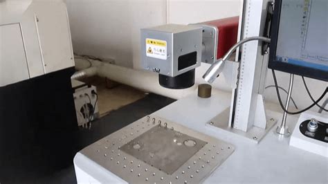 Ilustrace dílny, kde se vyrábí šperky, s laserovým gravírovacím strojem.