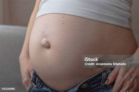 detailní záběr na bříško těhotné ženy s rukama