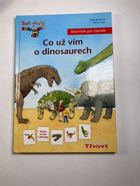 Dítě se zaujetím prohlíží knihu o dinosaurech