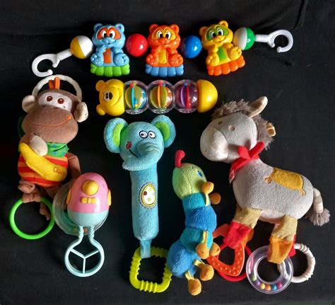 Detailní záběr na různé typy hraček na hrazdičce (chrastítka, plyšáci, zrcátko)