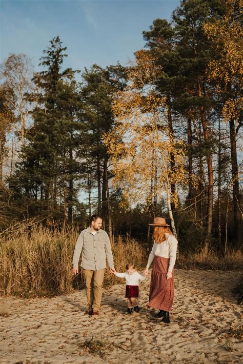 těhotný pár se prochází po podzimním parku