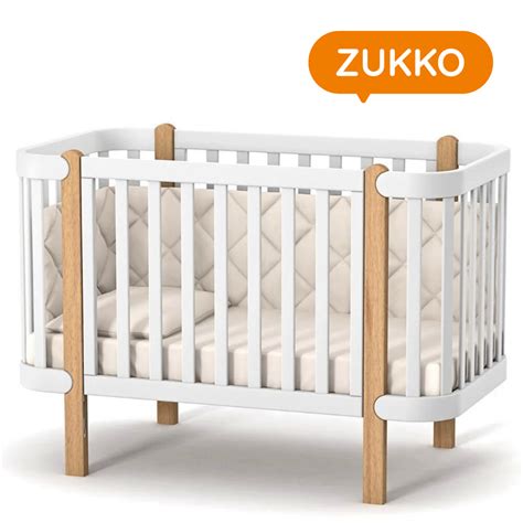 Fotografie dětské postýlky s viditelnými stopami po kousání