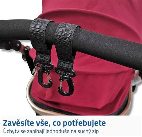 Ilustrace univerzálního držáku na tašku na pleny připevněného ke kočárku