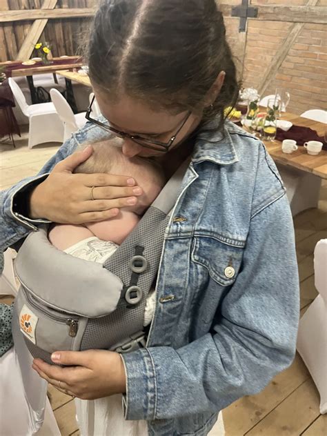 Ilustrace zobrazující matku kojící dítě, s důrazem na vzájemnou blízkost a pocit pohody.